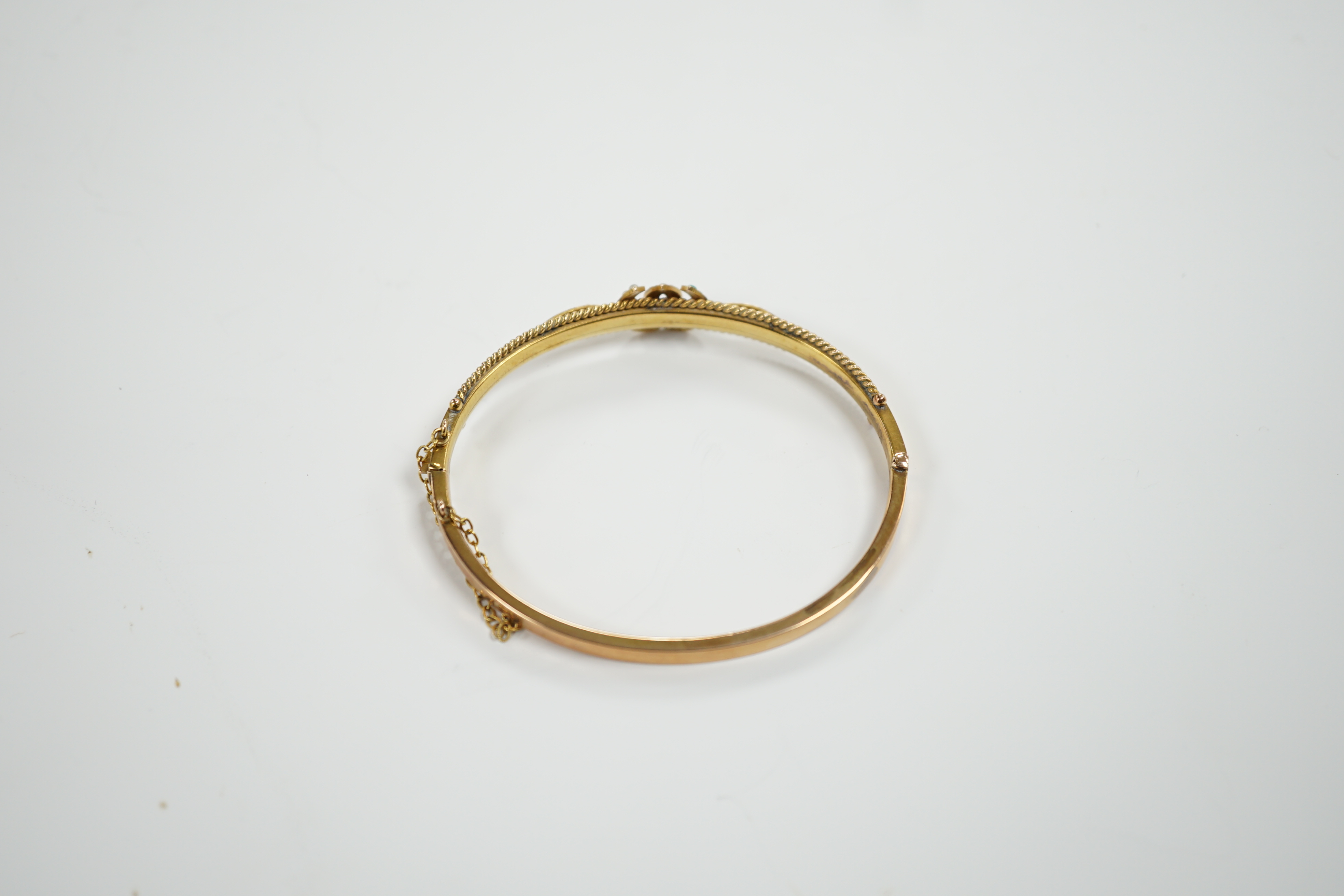 A 9ct gold, seed pearl and turquoise set twin horseshoe motif hinged bangle, gross weight 7.5 grams.